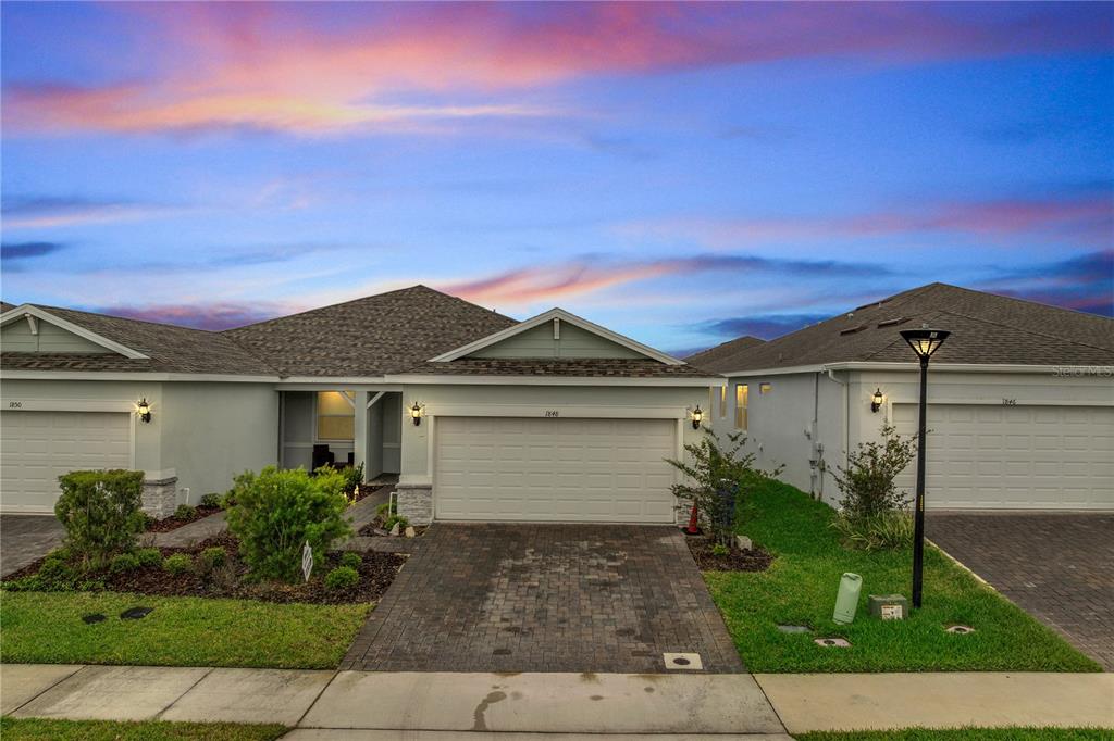 A suburban house with a paved driveway, a two-car garage, and a landscaped front yard — 1848 SPRING SHOWER CIRCLE, KISSIMMEE, FL