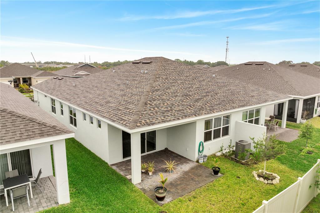 An aerial view of the back of a house with a paved patio and yard — 1848 SPRING SHOWER CIRCLE, KISSIMMEE, FL