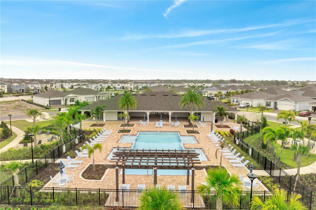 An aerial view of a community swimming pool with a pergola and surrounding residential homes — 1848 SPRING SHOWER CIRCLE, KISSIMMEE, FL