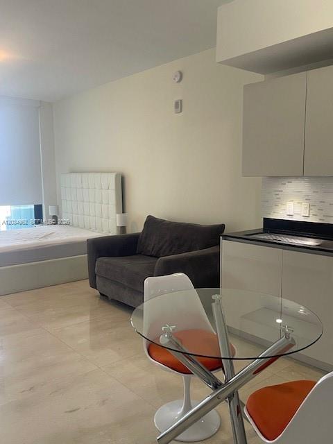 A studio apartment features a bed, a gray armchair, and a glass dining table — 1010 Brickell Ave # 3810, Miami FL 33131, MIAMI, FL