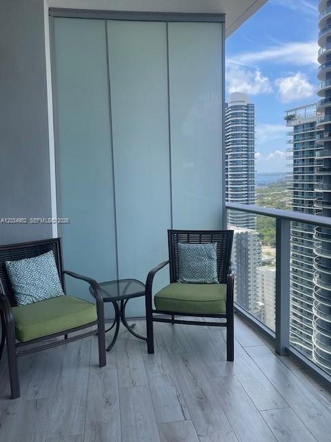 Two chairs and a small table sit on a balcony overlooking high-rise city buildings — 1010 Brickell Ave # 3810, Miami FL 33131, MIAMI, FL