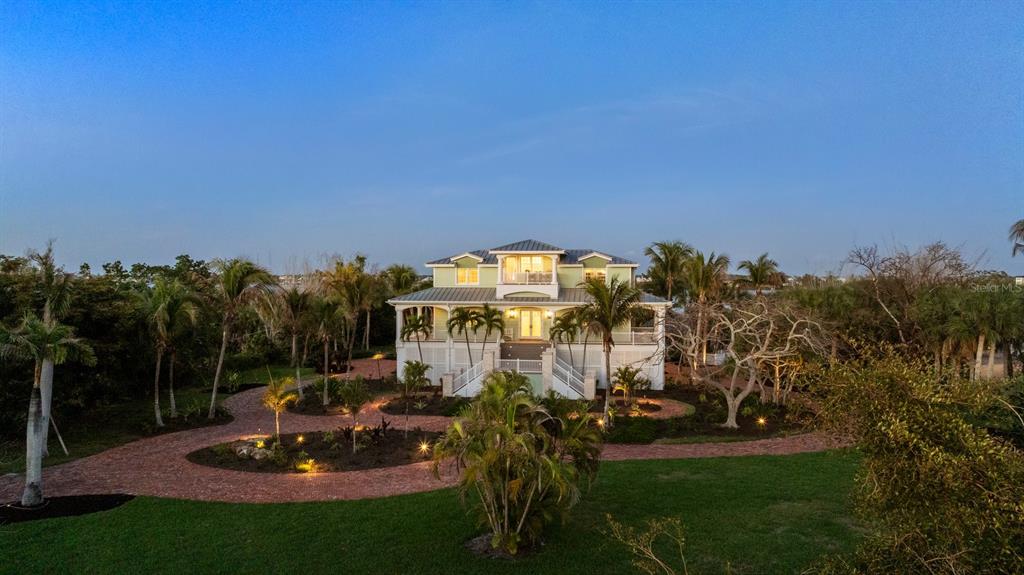 A multi-story house with a metal roof and brick driveway surrounded by palm trees — 10460 SUNNY DREAMS TERRACE, PLACIDA, FL