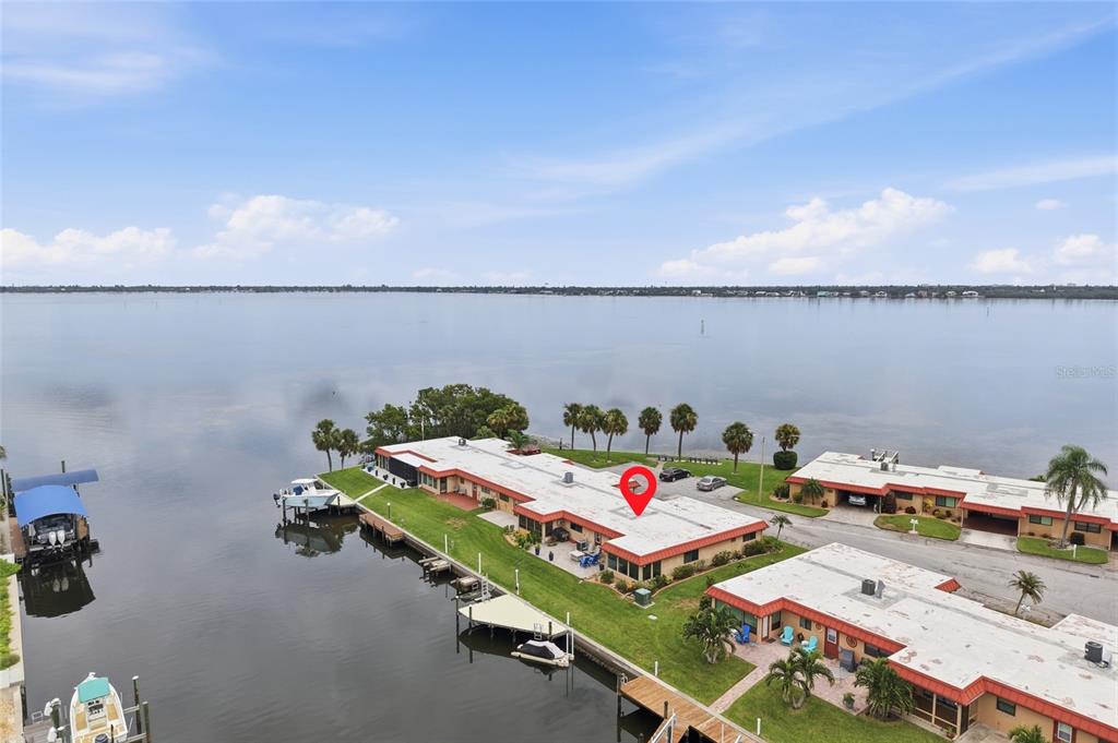 An aerial view shows waterfront residential buildings with boat docks and a large lake — 3844 CATALINA DRIVE UNIT 3844, BRADENTON, FL