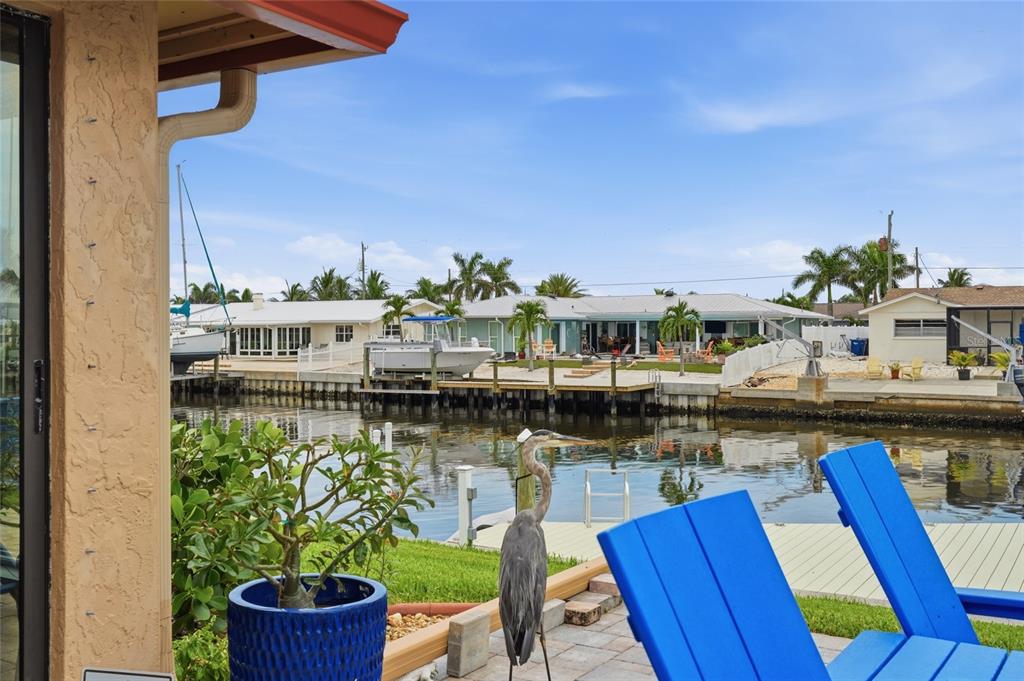 A backyard patio overlooks a canal with boats, a dock, and a bird statue — 3844 CATALINA DRIVE UNIT 3844, BRADENTON, FL