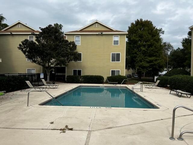 A rectangular swimming pool sits in front of two three-story apartment buildings — 3800 SW 20th Avenue # 305, Gainesville FL 32607, GAINESVILLE, FL