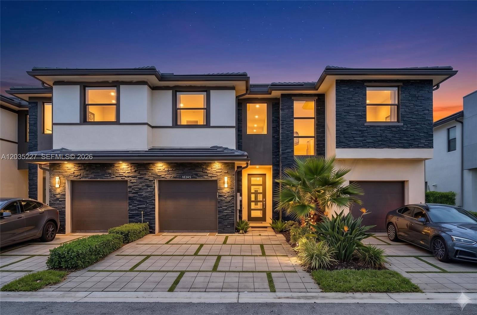 A modern two-story townhouse features a stone facade, a paved driveway, and two garage doors — 15841 NW 91st Ct, Miami Lakes FL 33018, MIAMI LAKES, FL
