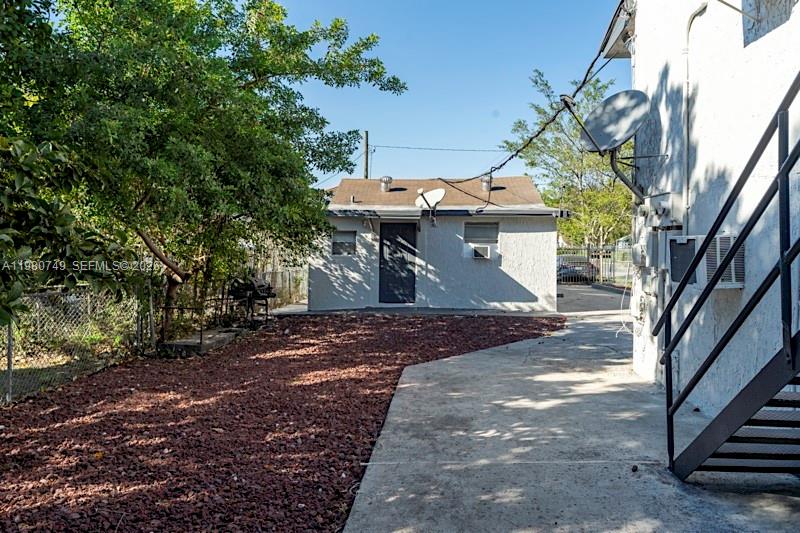 A small detached building sits behind a concrete patio and a red gravel yard — 2378 NW 60th St, Miami FL 33142, MIAMI, FL