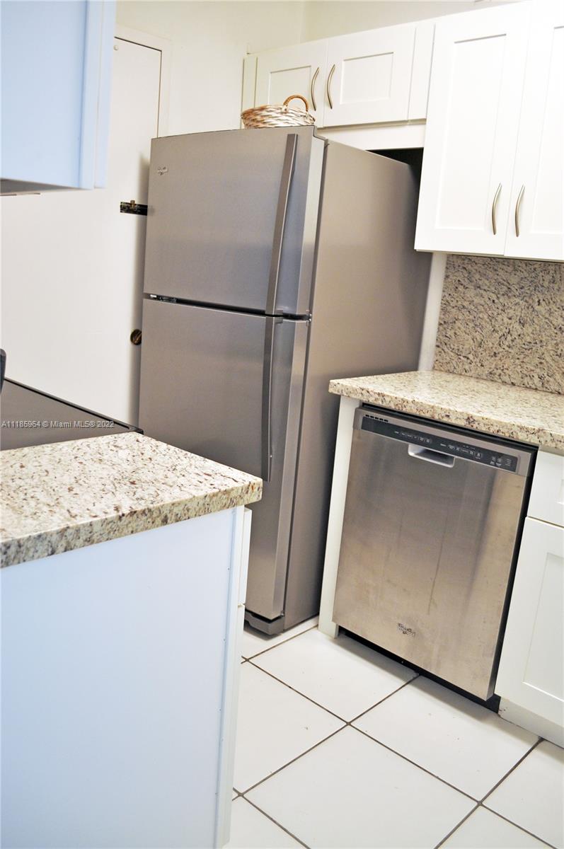 A kitchen features stainless steel appliances, white cabinets, and granite countertops — 100 Lincoln Rd # 910, Miami Beach FL 33139, MIAMI BEACH, FL