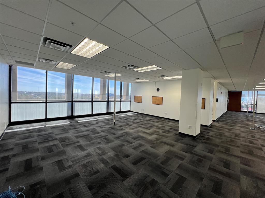 An empty office space features floor-to-ceiling windows, gray patterned carpeting, and a drop ceiling — 1255 CLEVELAND STREET UNIT 400, CLEARWATER, FL
