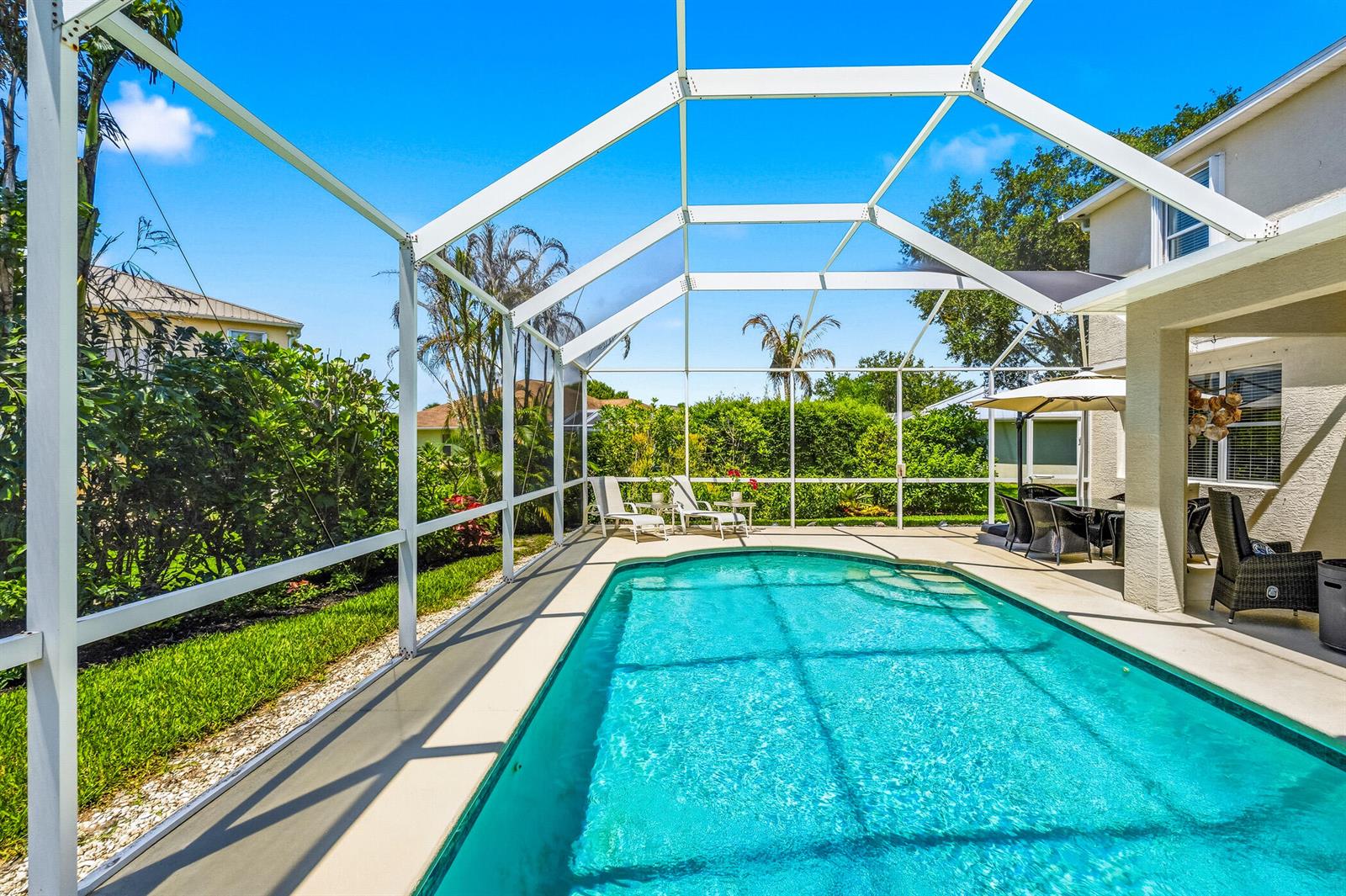 A screened-in swimming pool with a patio area and lounge chairs in a backyard — 6455 36th Lane, Vero Beach FL 32966, VERO BEACH, FL