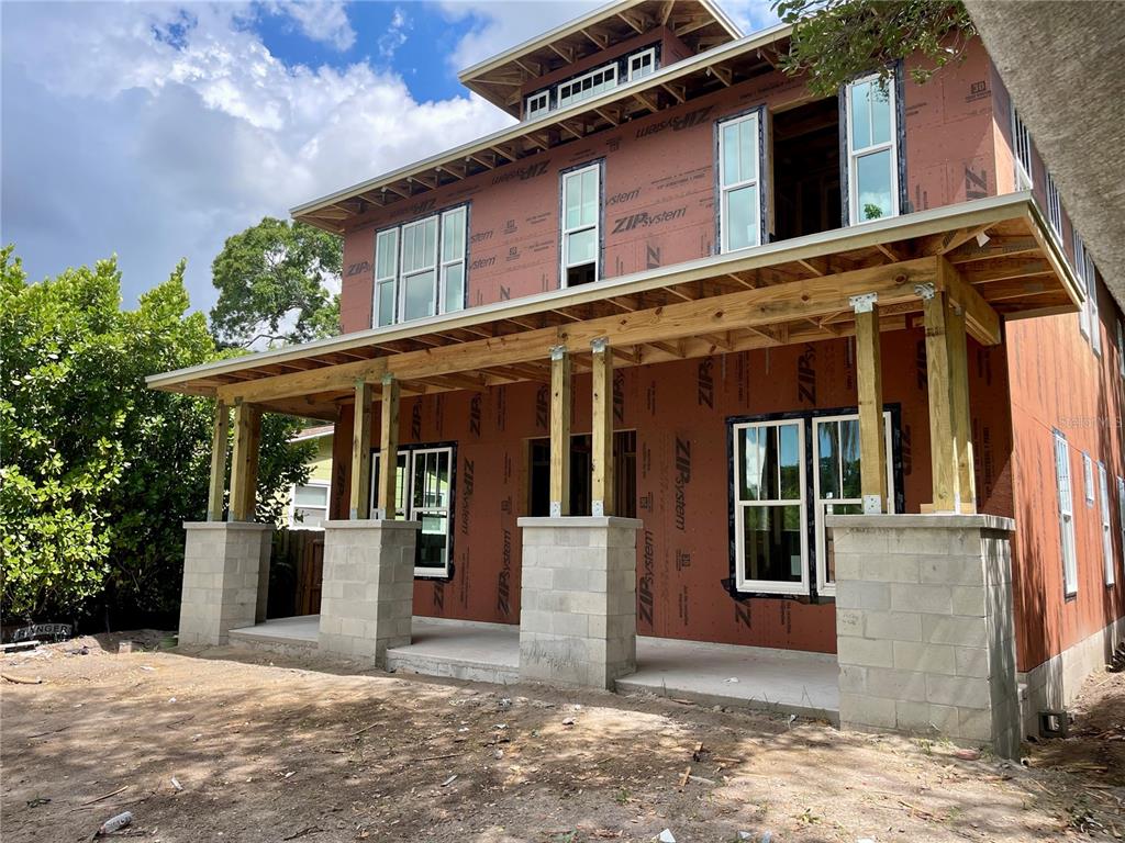 The exterior of a two-story house under construction features a covered porch with concrete pillars — 721 47TH AVENUE N, ST PETERSBURG, FL