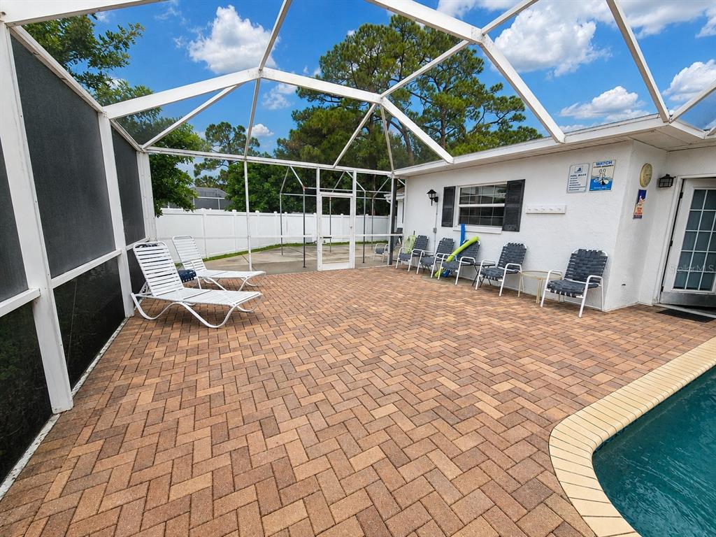 A single-story white house features a concrete driveway, a brick walkway, and several palm trees — 2130 PINEHURST STREET, SARASOTA, FL