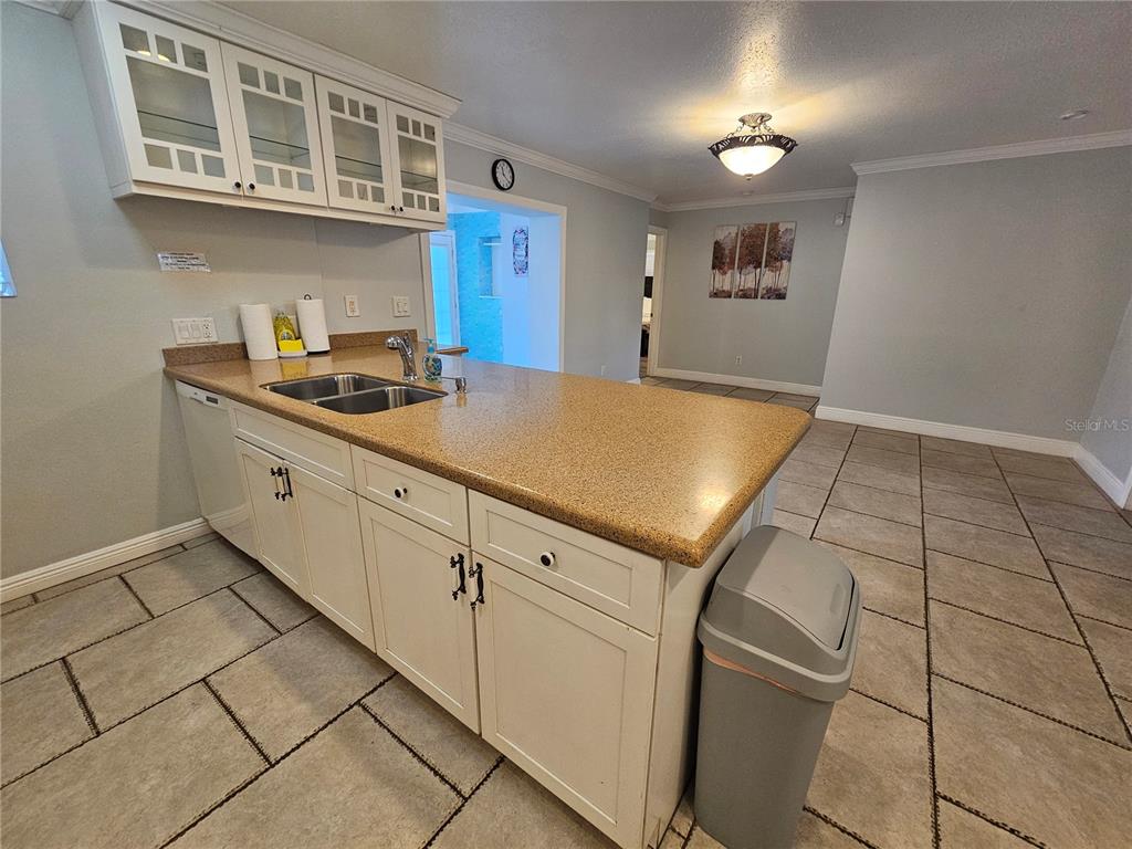 A kitchen island with a tan countertop and white cabinets sits on a tiled floor — 2130 PINEHURST STREET, SARASOTA, FL