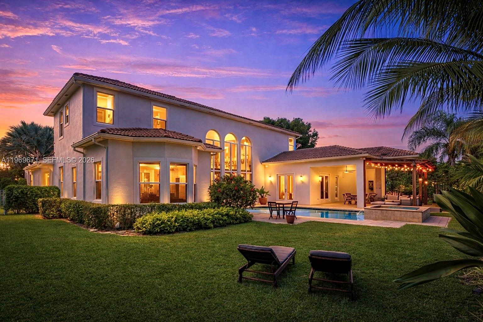 A two-story house with a pool, patio, and lawn at sunset — 12486 World Cup Ln, Wellington FL 33414, WELLINGTON, FL