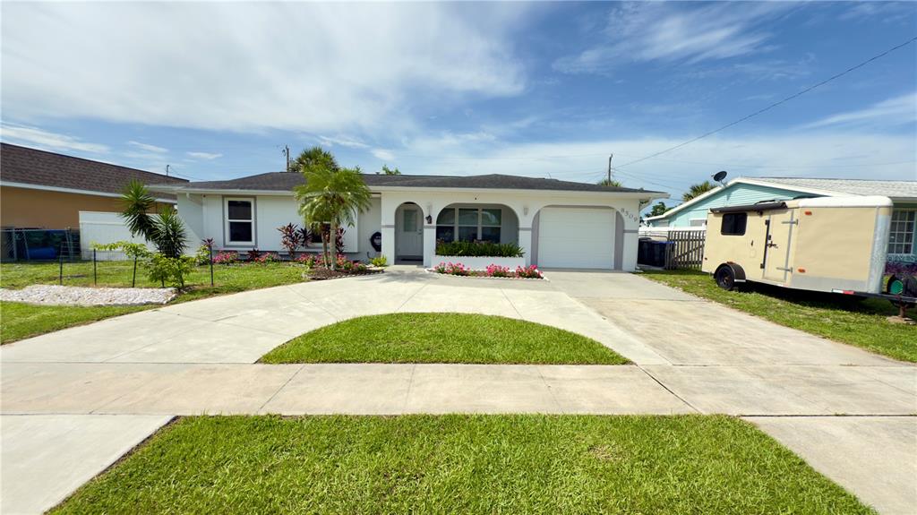 A single-story house with a white exterior, a concrete driveway, and a small front lawn — 8509 LA BOCA AVENUE, NORTH PORT, FL