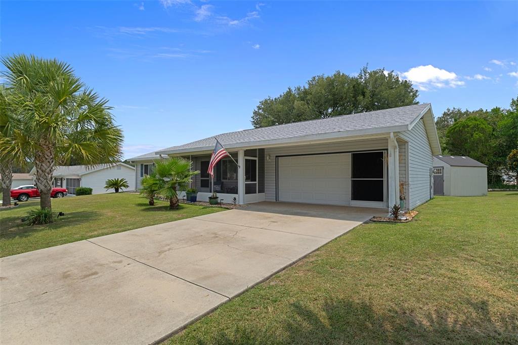 A single-story house with a concrete driveway, a screened-in porch, and a detached shed — 6264 SW 103RD STREET ROAD, OCALA, FL