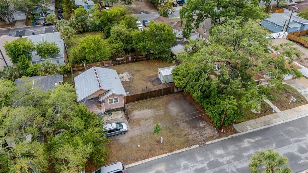 An aerial view shows a pink house with a metal roof and a large yard — 1127 ENGMAN STREET, CLEARWATER, FL