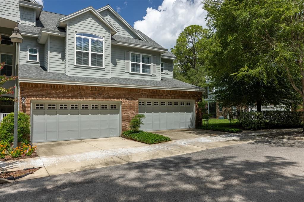 A two-story house with light gray siding, brick lower walls, and two garage doors — 1798 NW 34TH STREET UNIT 12, GAINESVILLE, FL