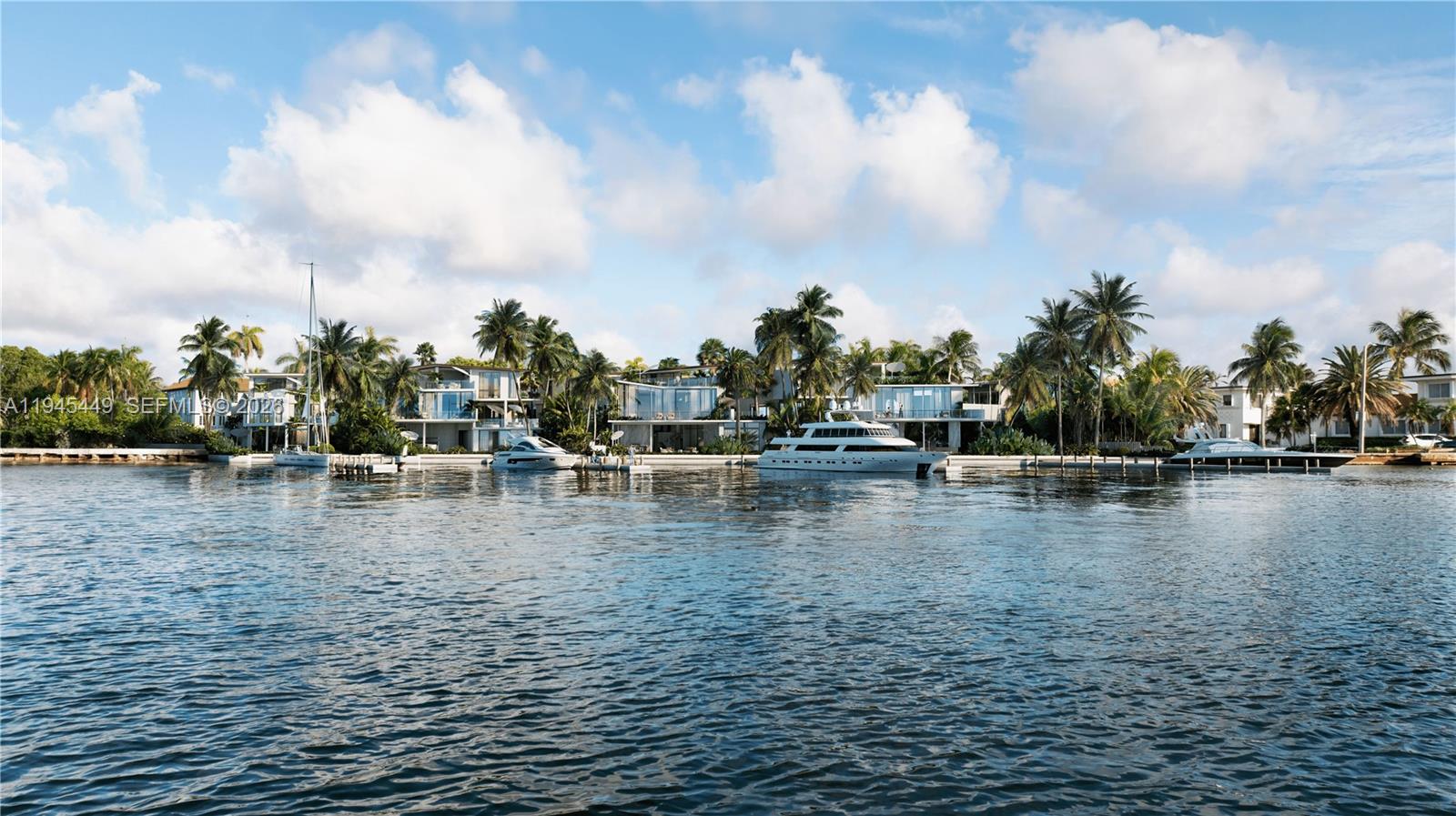 A view of modern waterfront homes with docked yachts along a canal under a blue sky — 7101 NE 10th Ave, Miami FL 33138, MIAMI, FL
