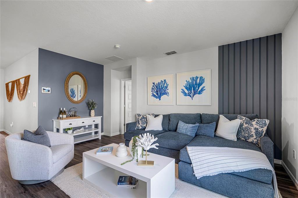 A living room features a blue sectional sofa, a white coffee table, and accent walls — 3594 RODEN ROAD, HAINES CITY, FL