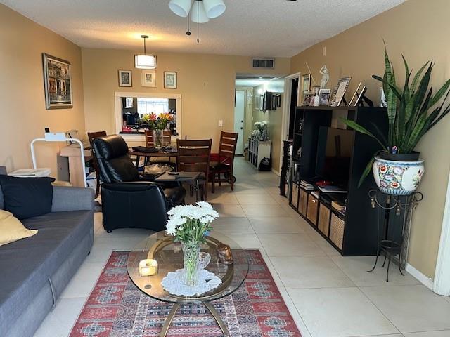 A living room features a grey sofa, a black recliner, a dining set, and tile flooring — 9330 Lagoon Place # 406, Davie FL 33324, DAVIE, FL