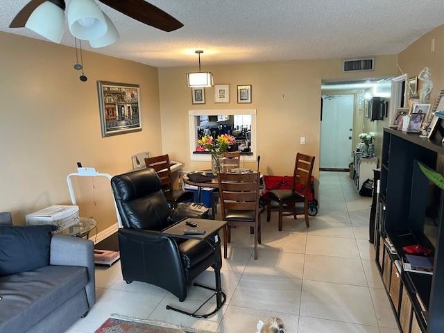A living room features a black recliner, a dining table, and tile flooring — 9330 Lagoon Place # 406, Davie FL 33324, DAVIE, FL