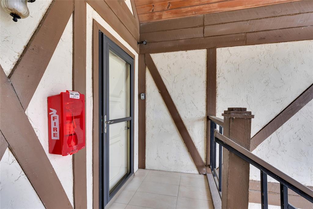 A red fire alarm box is mounted on the wall next to an exterior door — 500 NEWELL HILL RD UNIT 110D, LEESBURG, FL