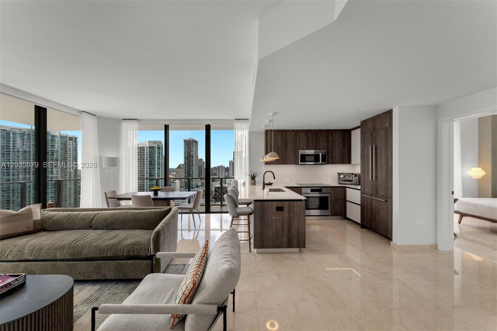 An open-concept living area features a modern kitchen with dark wood cabinetry and city views — 68 SE 6th St # 2612, Miami FL 33131, MIAMI, FL