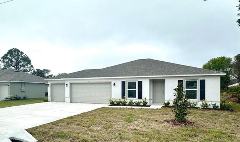 A single-story house with a white exterior, gray roof, and a three-car garage — 91 BRESSLER LANE, PALM COAST, FL