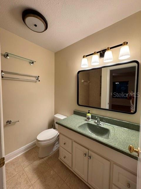 A bathroom features a green countertop, a vanity, a toilet, and a wall-mounted mirror — 11722 RAINTREE LAKE LANE UNIT C, TAMPA, FL