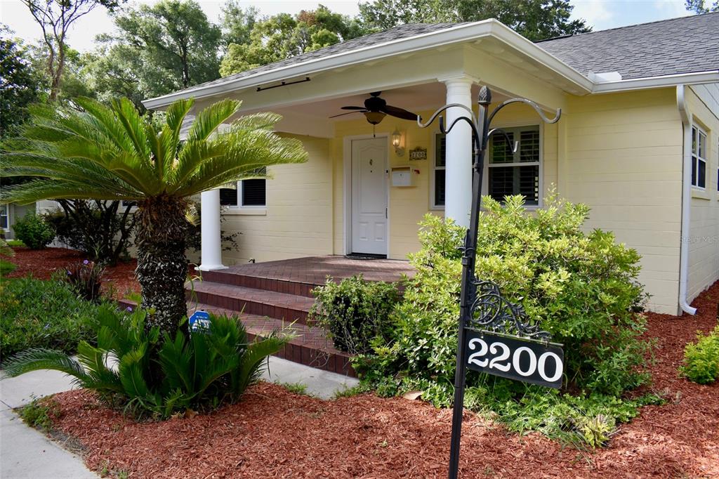 A yellow house with a covered front porch, a brick stoop, and a palm tree — 2200 E GORE STREET, ORLANDO, FL