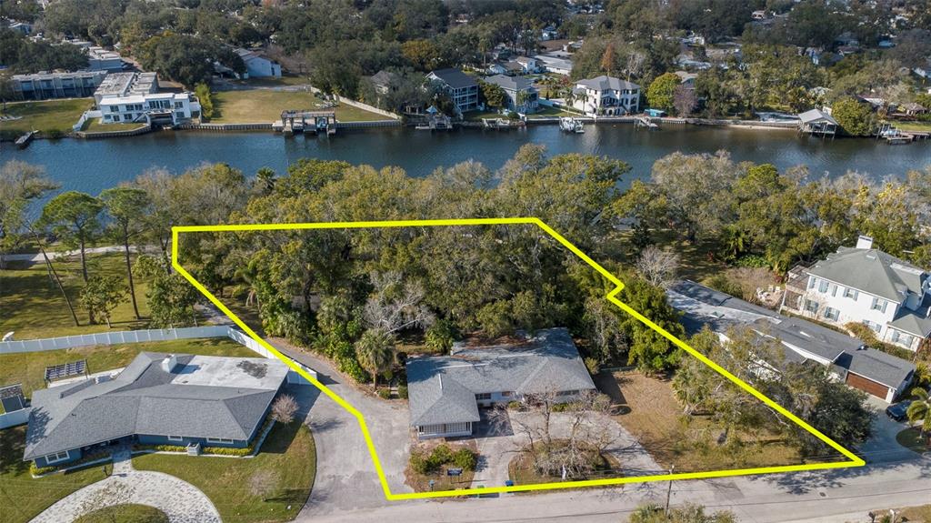 An aerial view shows a house on a lot outlined in yellow near a river — 3306 N PERRY AVENUE, TAMPA, FL