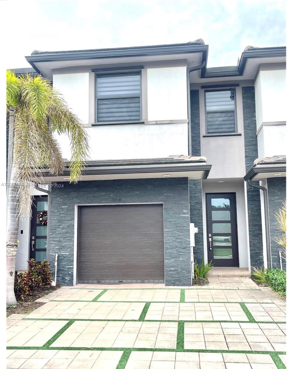 A two-story townhouse exterior features a dark stone facade, a garage, and a paved driveway — 9083 NW 159th St # 9083, Miami Lakes FL 33018, MIAMI LAKES, FL