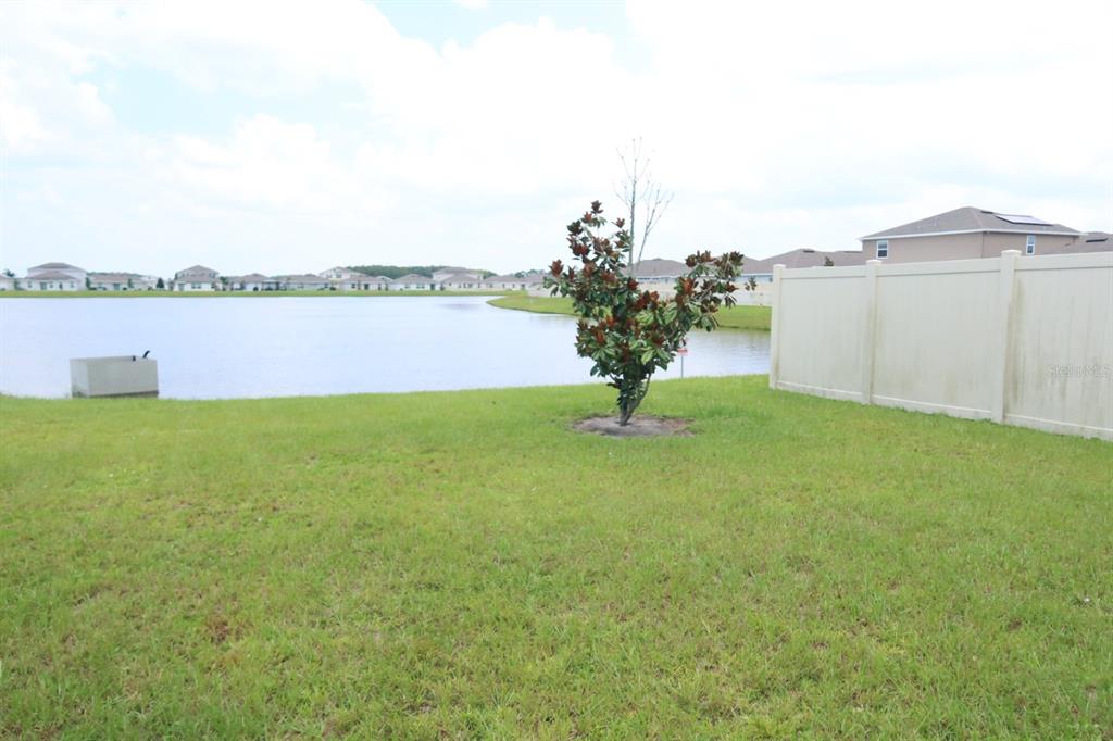 A living room features a stone fireplace with a mounted television and a gray sectional — 5121 FOUR STRAND COURT, ST CLOUD, FL