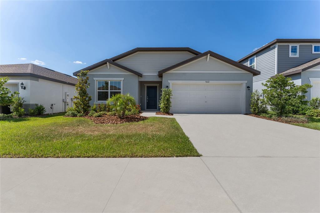 A single-story suburban house with a gray exterior, a two-car garage, and a concrete driveway — 9642 SUMMERS CAY CIRCLE, THONOTOSASSA, FL