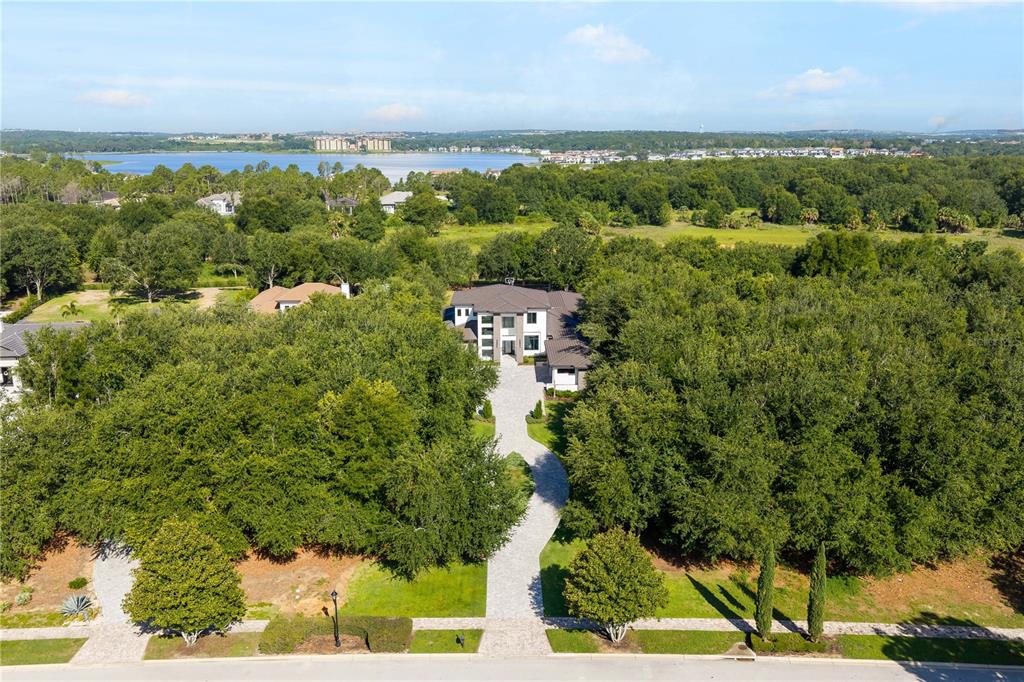 An aerial view shows a large house set back from the road behind dense trees — 15746 PENDIO DR, MONTVERDE, FL