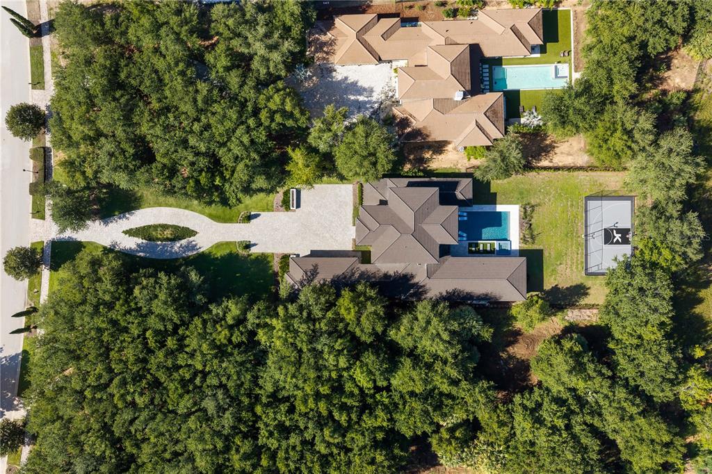 An aerial view shows two large houses with swimming pools, a sports court, and wooded landscaping — 15746 PENDIO DR, MONTVERDE, FL