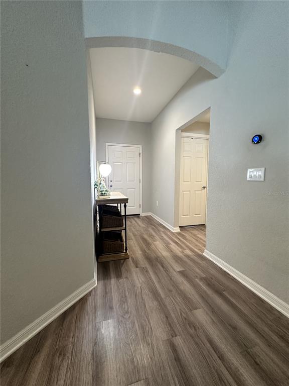An entryway features wood-look flooring, a white front door, and a small console table — 6911 GIDEON CIR, ZEPHYRHILLS, FL