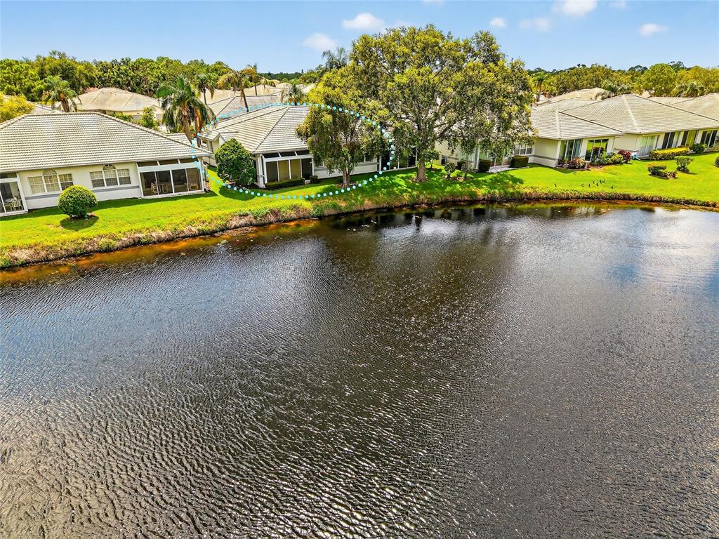 An aerial view shows a residential house with a screened lanai overlooking a pond — 5633 E LONG COMMON COURT UNIT 20, SARASOTA, FL