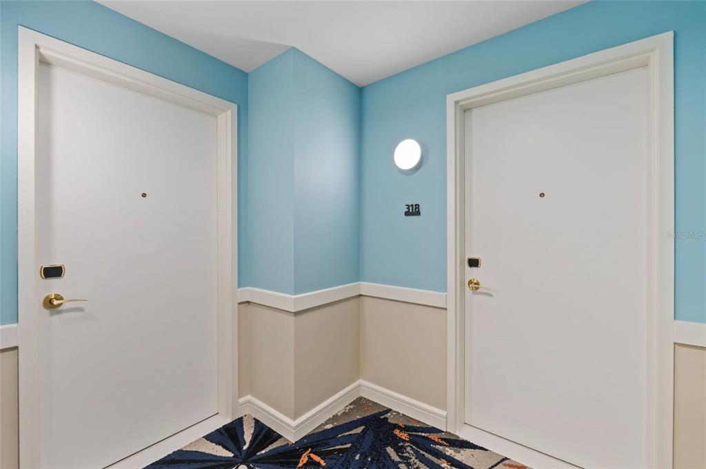 Two white doors with gold hardware flank a corner wall with a room number sign — 3151 SUNSET WALK DRIVE UNIT 1316 and 1318, KISSIMMEE, FL