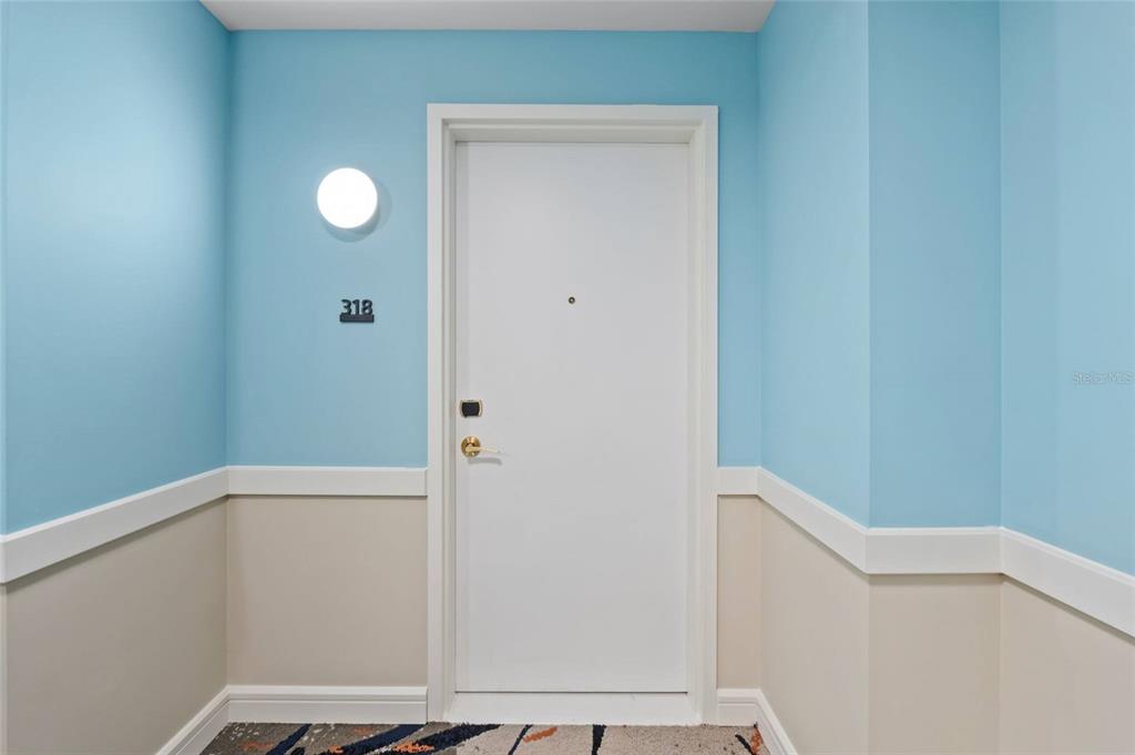 A white door with a number 318 sign is centered against light blue and beige walls — 3151 SUNSET WALK DRIVE UNIT 1316 and 1318, KISSIMMEE, FL