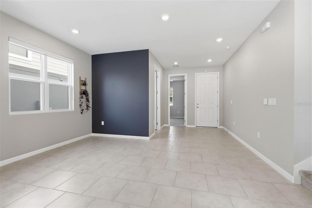 An open-concept kitchen and dining area features white cabinetry, a center island, and tile flooring — 1037 RIVER OTTER WAY, DELAND, FL