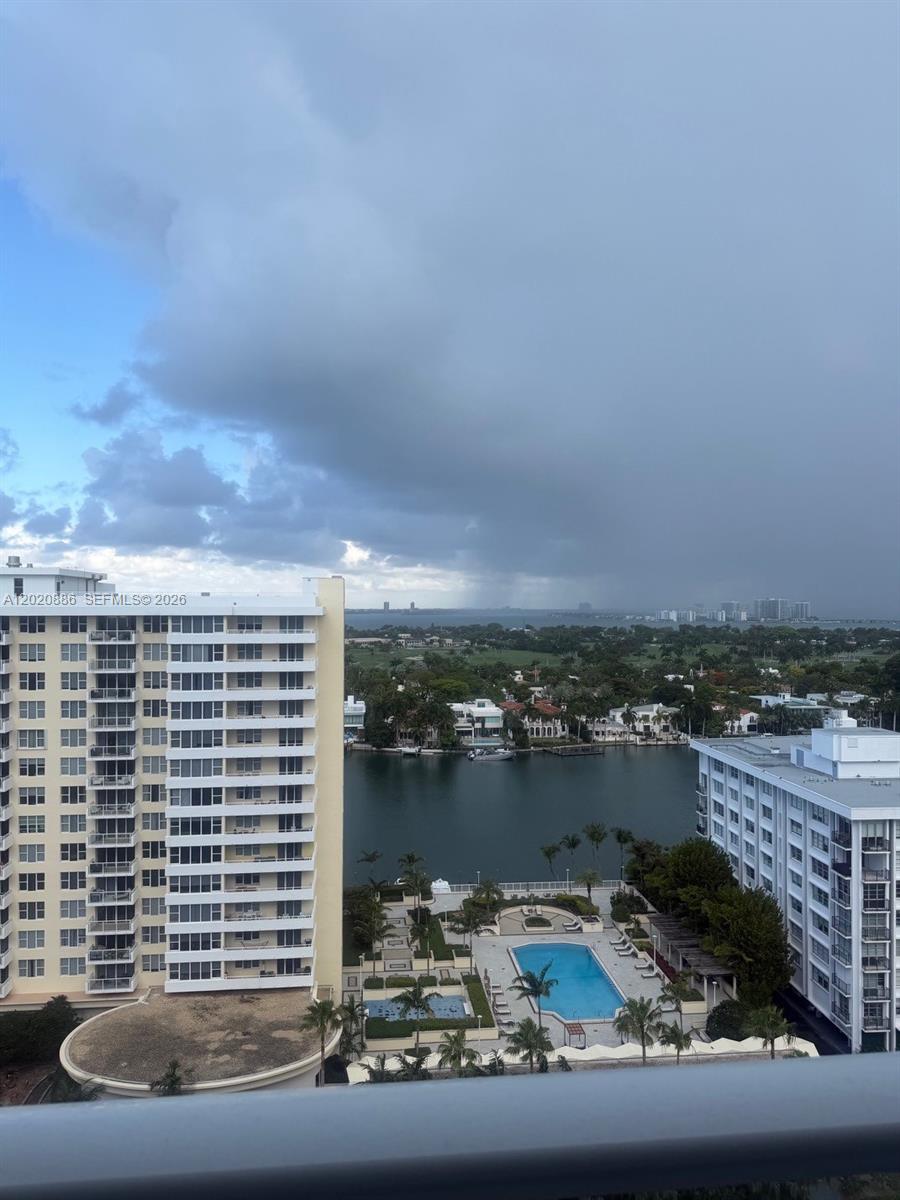 An elevated view shows a swimming pool between two apartment buildings overlooking a bay — 5601 Collins Ave # 1718, Miami Beach FL 33140, MIAMI BEACH, FL