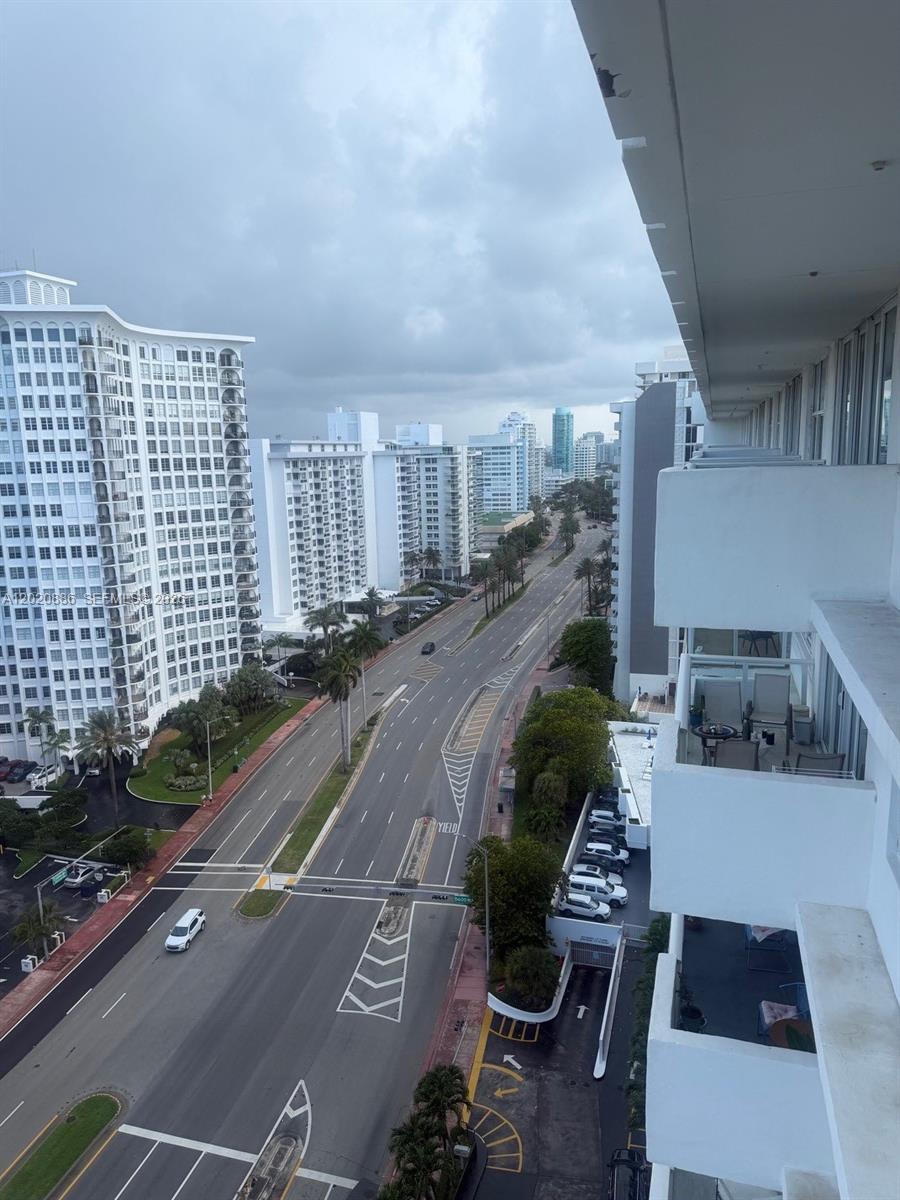 An elevated view of a multi-lane city street lined with tall white residential buildings — 5601 Collins Ave # 1718, Miami Beach FL 33140, MIAMI BEACH, FL