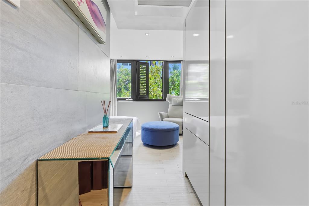 A modern room features a mirrored console table, a blue ottoman, and a window view — 63 KINGS CT UNIT #3A, SAN JUAN, PR