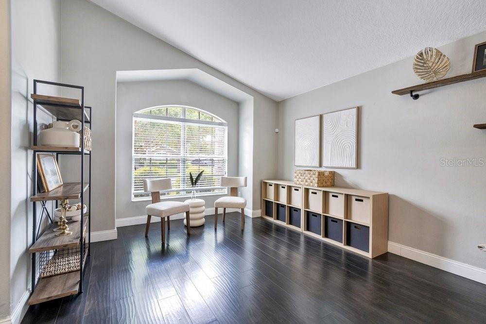 A room with dark wood floors, a window, two chairs, and a cube storage unit — 9745 DORIATH CIRCLE, ORLANDO, FL