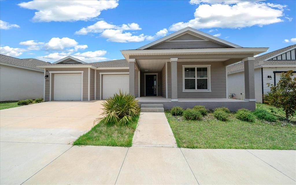 A single-story house with a two-car garage, covered front porch, and a concrete driveway — 6506 SW 75TH AVE ROAD, OCALA, FL