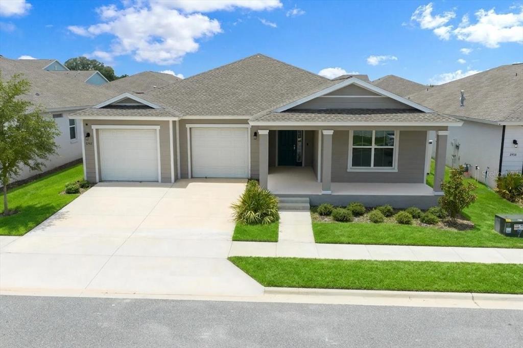 A single-story house with a two-car garage, covered front porch, and gray siding — 6506 SW 75TH AVE ROAD, OCALA, FL
