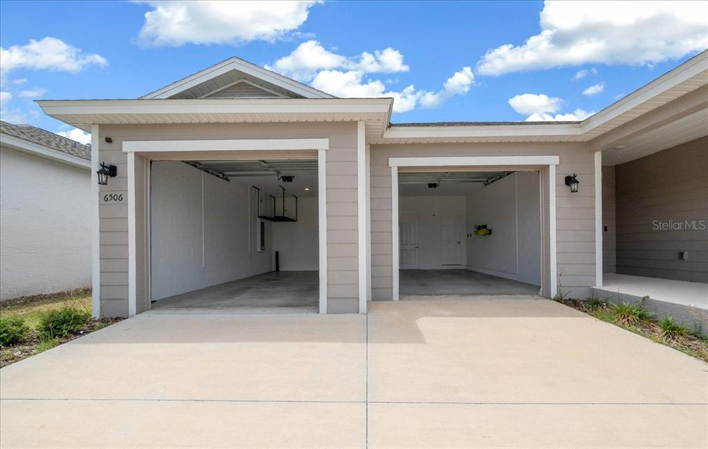 A two-car garage with an open driveway is attached to the front of a house — 6506 SW 75TH AVE ROAD, OCALA, FL