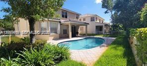 A two-story house features a backyard swimming pool, a covered patio, and surrounding green landscaping — 13161 SW 45th Dr, Miramar FL 33027, MIRAMAR, FL